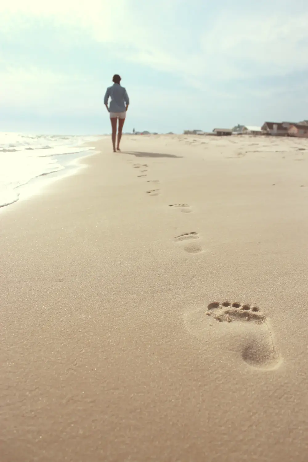 Ein Mensch geht allein am Strand, Fußspuren im Sand